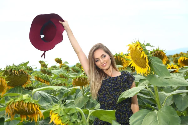Šťastná Mladá Žena Kráčí Kvetoucí Slunečnice Pole Házet Klobouk Nahoru — Stock fotografie
