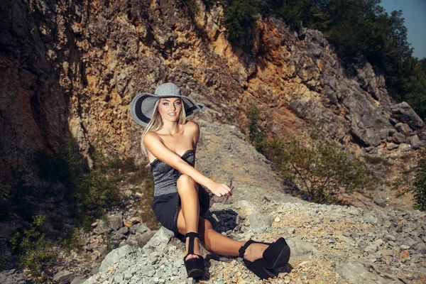 若いです美しいです女性で夏ドレスポーズに岩の背景 — ストック写真