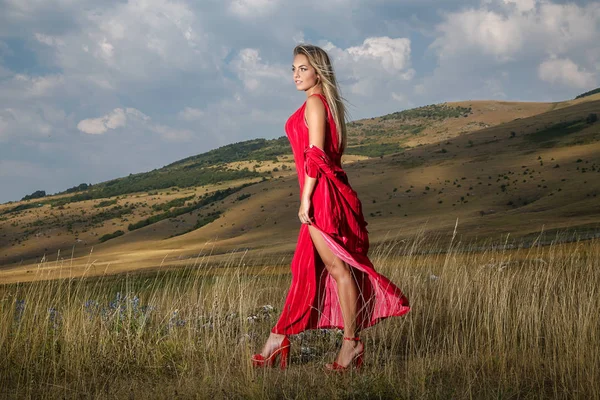 Eine Schöne Blondine Einem Sommerroten Kleid Geht Über Ein Bergfeld — Stockfoto