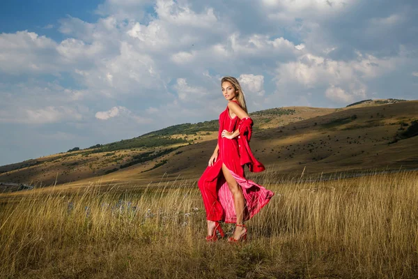 Eine Schöne Blondine Einem Sommerroten Kleid Geht Über Ein Bergfeld — Stockfoto
