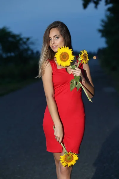 Krásná Mladá Žena Červených Šatech Drží Slunečnici Západu Slunce — Stock fotografie