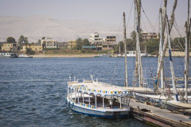 Ahşap tekneler yolcu taşıyan Nil Nehri boyunca yuvalanmış 
