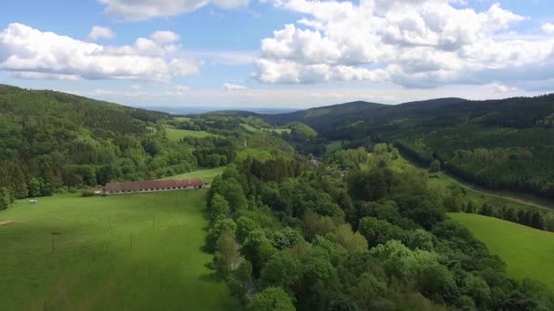 Vista aérea da hora de verão nas montanhas na fronteira com a Polónia e República Checa. Floresta de pinheiro e nuvens sobre o céu azul. Vista de cima . — Vídeo de Stock