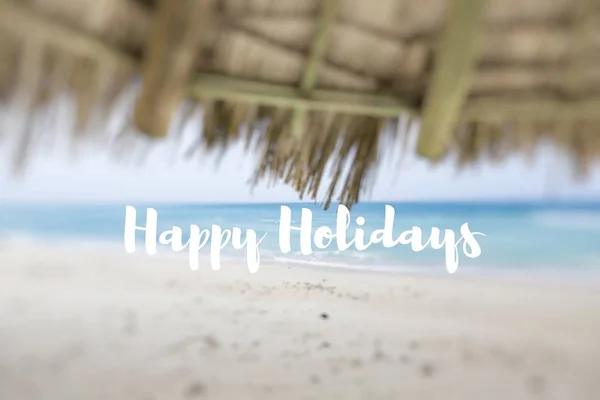 Felices Fiestas. Un paraguas de paja en una hermosa playa tropical . — Foto de Stock