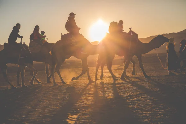 Caravana de camellos con gente atravesando las dunas de arena en el Sa — Foto de Stock