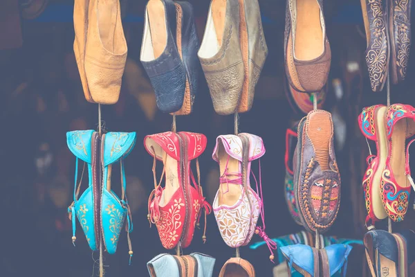 Moroccan leather goods bags and slippers at outdoor market in Ma