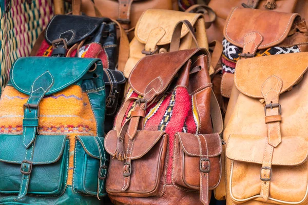 Moroccan leather goods bags and slippers at outdoor market in Ma