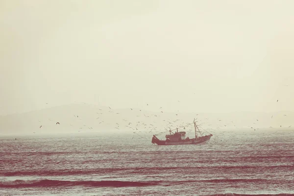 Rybářská loď s západ slunce v pozadí v Essaouira, Maroko — Stock fotografie