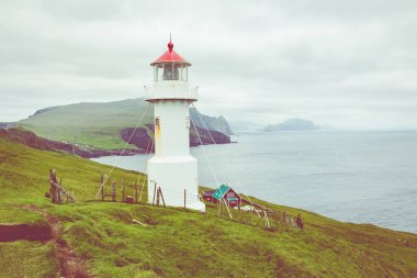 Faroe adalarındaki Mykines deniz feneri ve kayalıklar. Yürüyüş noktası.