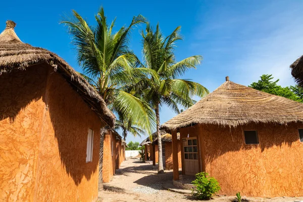 Resort turístico tradicional no Senegal. Grandes palmeiras verdes . — Fotografia de Stock