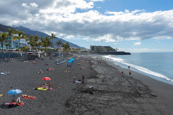 Puerto Naos Strand und Sonnenanbeter am Strand mit schwarzer Lava — Stockfoto