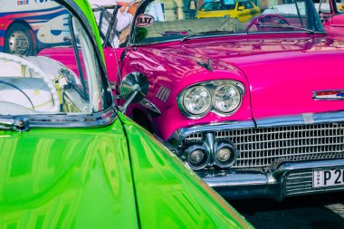 HAVANA, CUBA - 10 Aralık 2019 Havana, Küba 'da klasik Amerikan arabası. Renkli binalar ve eski arabalarla tipik Havana şehir manzarası.