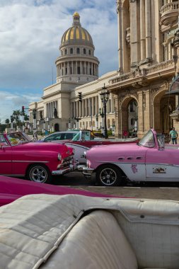 HAVANA, CUBA - 10 Aralık 2019 Havana, Küba 'da klasik Amerikan arabası. Renkli binalar ve eski arabalarla tipik Havana şehir manzarası.
