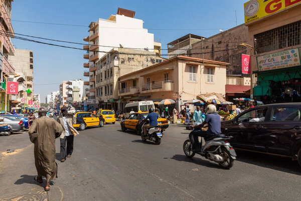 DAKAR, SENEGAL - NOVEMBER 11, 2019: People working and traffic at Senegal capital Dakar, West Africa.