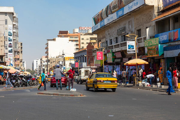 DAKAR, SENEGAL - NOVEMBER 11, 2019: People working and traffic at Senegal capital Dakar, West Africa.