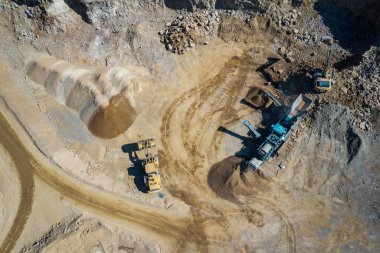 Endüstriyel maden ocağının havadan görünüşü. Çalışan bir sürü makineyle birlikte açık maden ocağı. Yukarıdan drone görünümü.