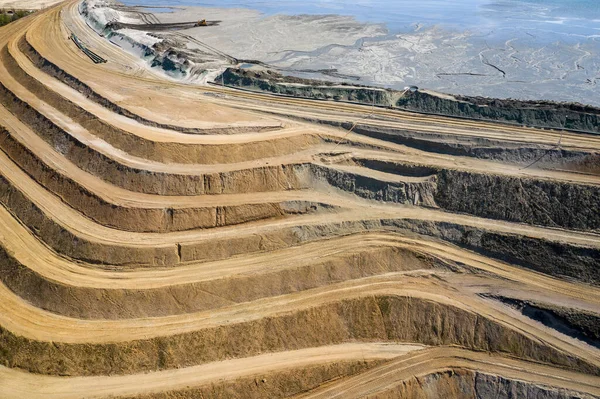 Mineral açık maden ocağındaki endüstriyel terasların havadan görünüşü. Açık madencilik. Yukarıdan drone görünümü.