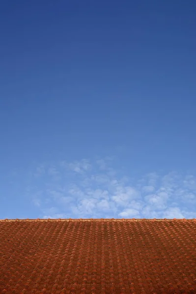 minimal red roof on clear blue sky