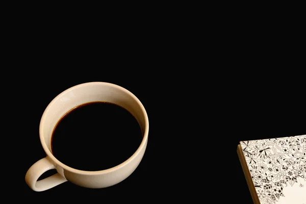 Notizbuch und schwarzer Kaffee in weißer Tasse. — Stockfoto