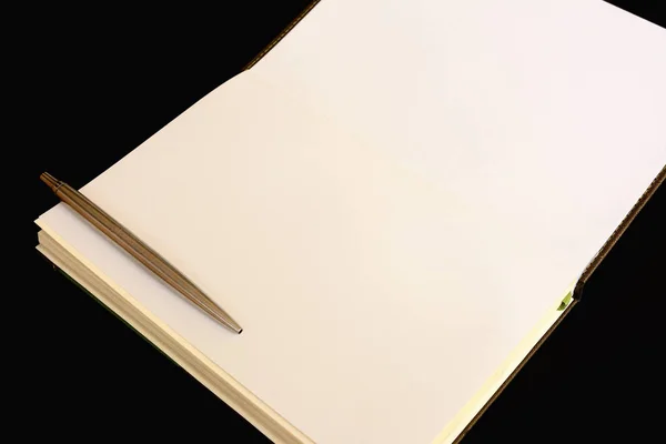 Notebook and pen isolated on black background — Stok fotoğraf
