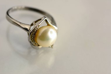 Elmaslı eski inci yüzük, beyaz arkaplanda yansıma.