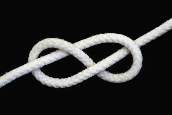 一条白色绳子 图八结 与黑色背景隔离 — 图库照片