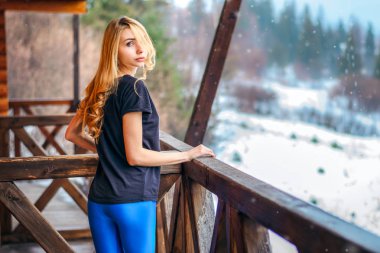 uzun sarı kıvırcık saçlı kız kış bir ahşap evin verandada olduğunu