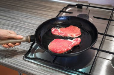 bir dökme demir tava üzerinde çiğ et pişirilir