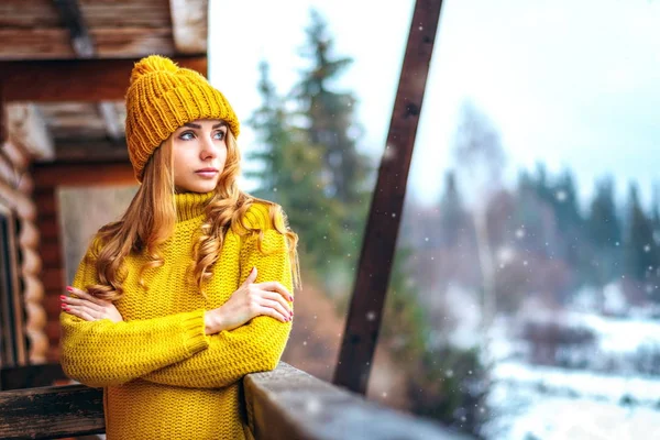 Девушка в вязаном свитере смотрит на снег — стоковое фото