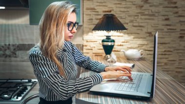 çekici kız bardaklarda bir dizüstü bilgisayarda yazarak