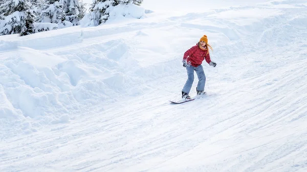 Holka jede na snowboardu na sjezdovky — Stock fotografie