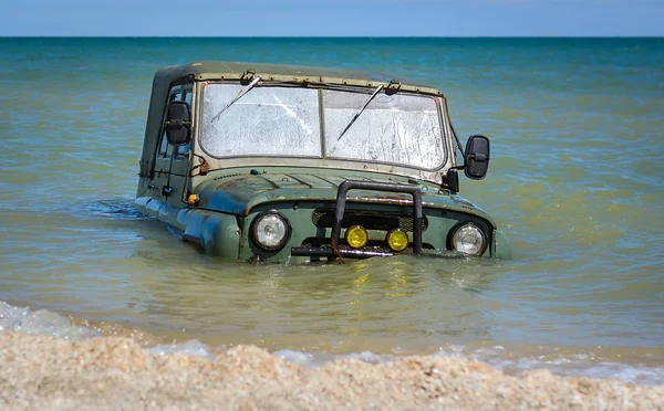 car stuck mud or submerged in the sea water on beach ocean or sea