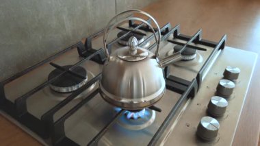 Çelik metal su ısıtıcısı ev gazı sobasında kaynıyor, evde kaynatılan su ise içeride çay buharı.