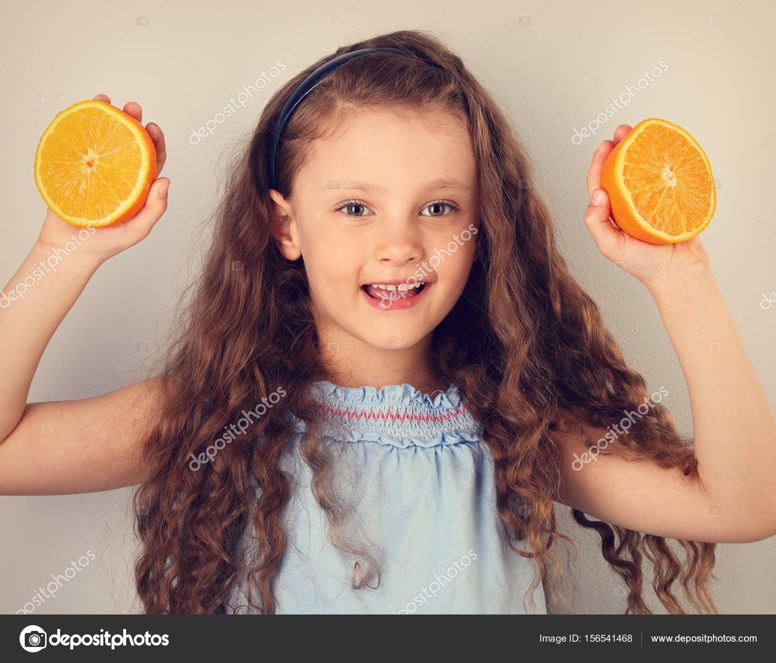 Cute Smiling Happy Kid Girl With Curly Hair Style Holding Citrus