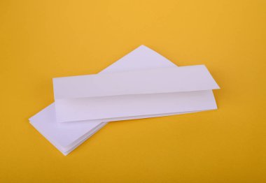 iki beyaz kağıt dört kat broşürü mockup Sarı zemin üzerine