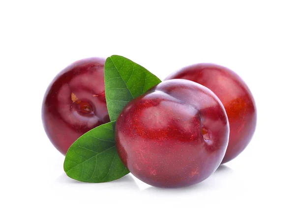 Três inteiros de ameixa vermelha cereja com folhas verdes isoladas no whi — Fotografia de Stock