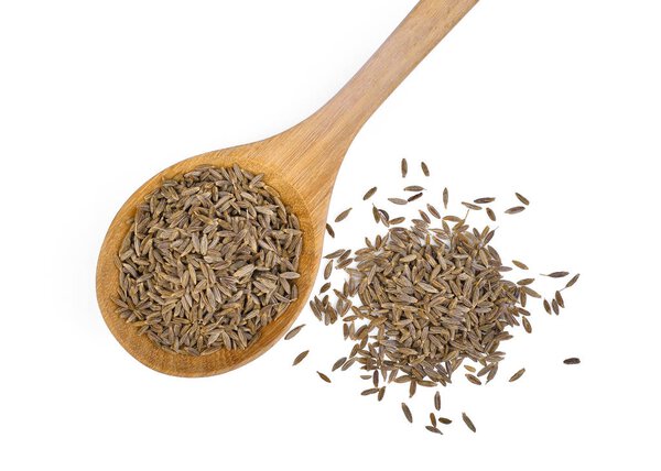 dried cumin seed or caraway in wooden spoon isolated on white ba