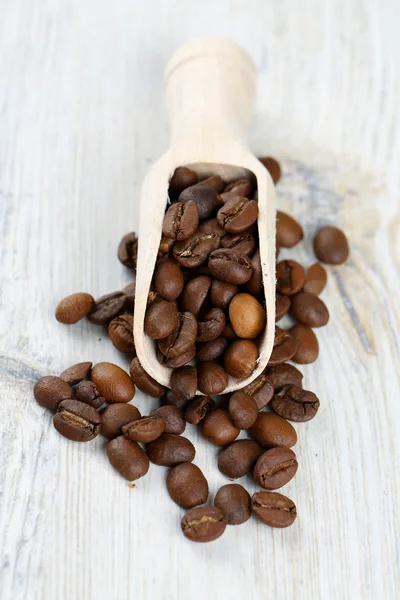 Granos de café en la superficie de madera — Foto de Stock