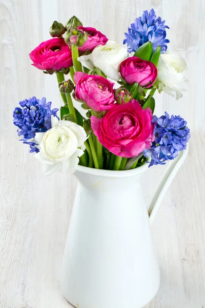 Ranunculus and hyacinth flowers in a pitcher — Stock Photo, Image