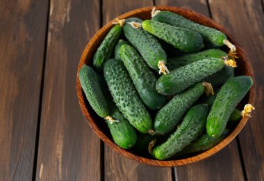 Ahşap yüzeydeki bir kasede salatalıklar.