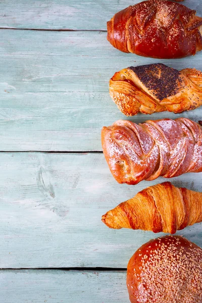 Fresh sweet bun assortment on wooden surface — Stock Photo, Image