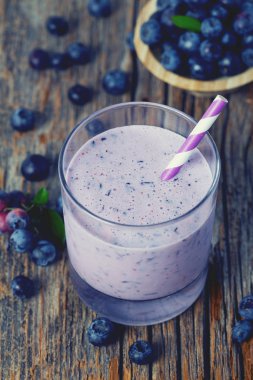 ahşap yüzeyüzerinde bir bardak yaban mersini smoothie