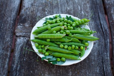 koyu ahşap yüzeyde taze bezelye