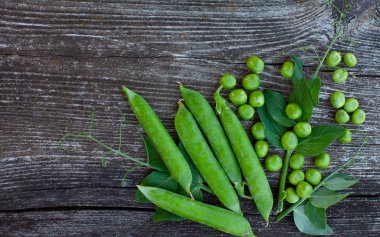 koyu ahşap yüzeyde taze bezelye
