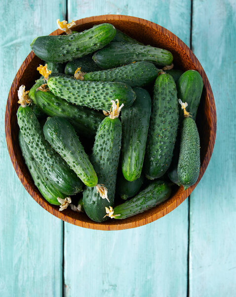 огурцы в чаше на деревянной поверхности
