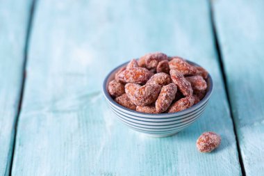 Tahta bir yüzeyde şekerli bademler