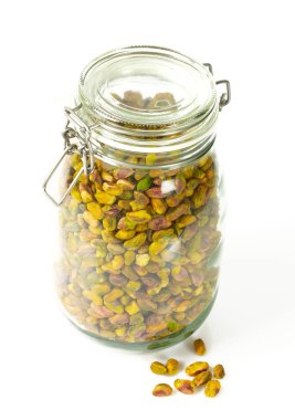 beyaz izole cam bir kavanozda ham antep fıstığı