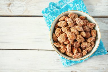 Beyaz ahşap yüzeyde karamelize edilmiş badem.