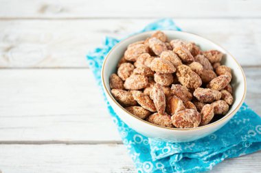 Beyaz ahşap yüzeyde karamelize edilmiş badem.