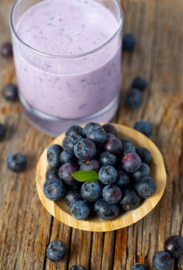 ahşap yüzeyüzerinde bir bardak yaban mersini smoothie